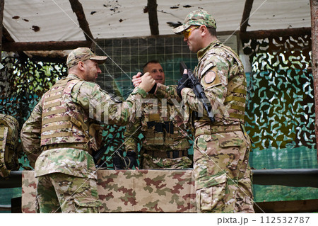 A highly trained military unit strategizes and organizes a tactical mission while studying a military map during a briefing session 112532787