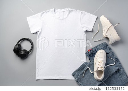 T-shirt, jeans and white sneakers on gray background top view 112533152