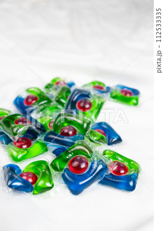 Lots of laundry pods on satin fabric close-up. 112533335