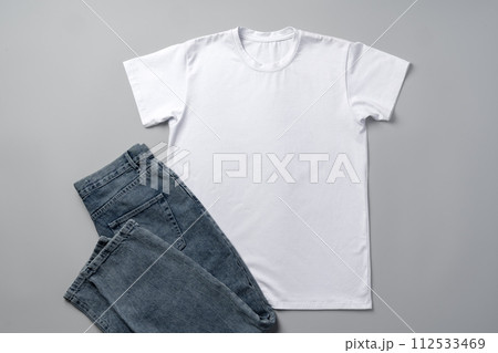 Cotton T-shirt and jeans on gray background top view Cotton T-shirt and jeans on gray background top view 112533469