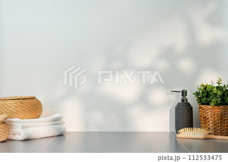 Soap dispenser and spa towels on white background in shadow 112533475