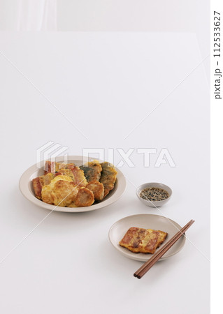 On two plates, there's a pancake with soy sauce and chopsticks On two plates, there's a pancake with soy sauce and chopsticks 112533627