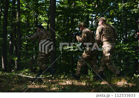 A specialized military antiterrorist unit conducts a covert operation in dense, hazardous woodland, demonstrating precision, discipline, and strategic readiness A specialized military antiterrorist unit conducts a covert operation in dense, hazardous woodland, demonstrating precision, discipline, and strategic readiness 112533633