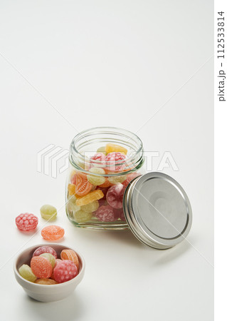 The fruit shaped candy is filled in a glass jar and on a plate 112533814
