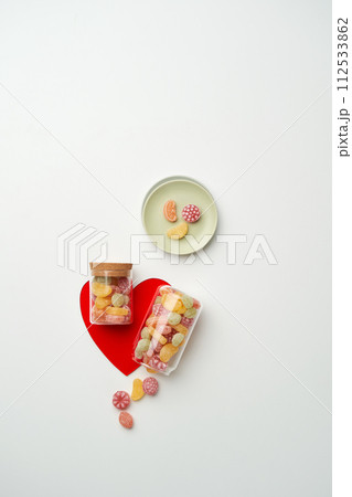 There is a fruit shaped candy in a bottle on the heart object 112533862