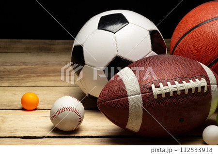 Set of various sport balls on wooden floor on black background 112533918