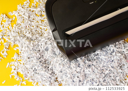 Office paper shredder on yellow studio background 112533925