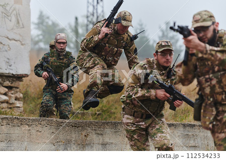 A highly trained elite military unit, clad in camouflage, skillfully navigates through perilous forest terrain, overcoming obstacles and executing a precise and covert mission A highly trained elite military unit, clad in camouflage, skillfully navigates through perilous forest terrain, overcoming obstacles and executing a precise and covert mission 112534233