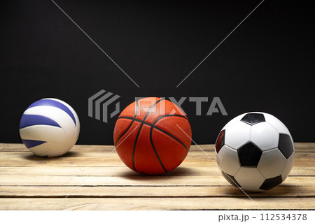 Set of various sport balls on wooden floor on black background 112534378
