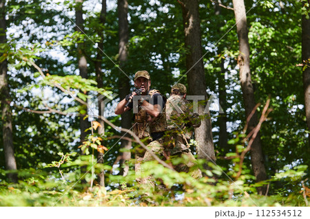 A specialized military antiterrorist unit conducts a covert operation in dense, hazardous woodland, demonstrating precision, discipline, and strategic readiness 112534512