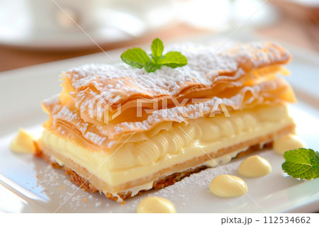 A piece of Napoleon cake or Mille-feuille topped with fluffy whipped cream and vibrant red raspberries A piece of Napoleon cake or Mille-feuille topped with fluffy whipped cream and vibrant red raspberries 112534662