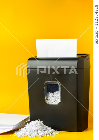 Office paper shredder on yellow studio background Office paper shredder on yellow studio background 112534818