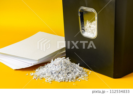 Office paper shredder on yellow studio background Office paper shredder on yellow studio background 112534833