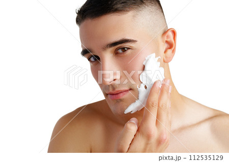 Young handsome man applying shaving foam against white background Young handsome man applying shaving foam against white background 112535129