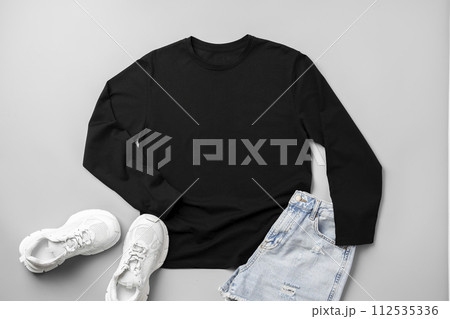 T-shirt, jeans and white sneakers on gray background top view 112535336