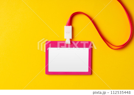 Blank nametag on a string on yellow background copy space Blank nametag on a string on yellow background copy space 112535448