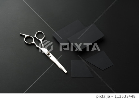 Hairdressing scissors and businesscard mock up on black background Hairdressing scissors and businesscard mock up on black background 112535449