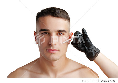 Handsome young man face and beautician hands with syringe making cosmetic injection in face 112535770