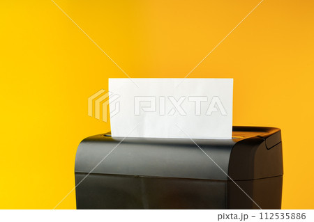 Office paper shredder on yellow studio background 112535886