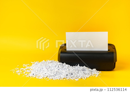 Office paper shredder on yellow studio background Office paper shredder on yellow studio background 112536114