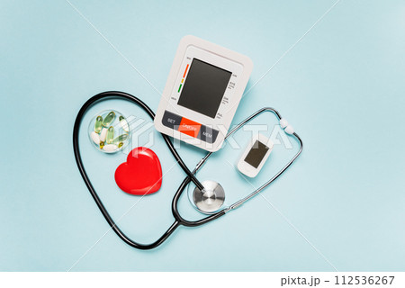 stethoscope, heart model, pills, and digital devices on Pale Blue Background symbolizing love and care in the medical field. stethoscope, heart model, pills, and digital devices on Pale Blue Background symbolizing love and care in the medical field. 112536267