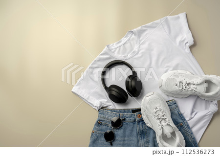 White T-shirt, jeans and sneakers on beige background White T-shirt, jeans and sneakers on beige background 112536273