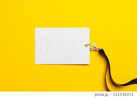 Blank nametag on a string on yellow background copy space Blank nametag on a string on yellow background copy space 112536311
