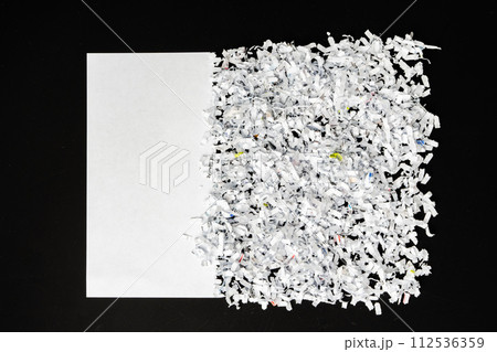Shredded white paper on black background close up 112536359