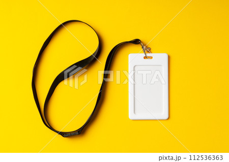 Blank nametag on a string on yellow background copy space 112536363