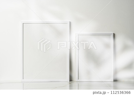 Blank wooden frame mock up on desk near white wall 112536366