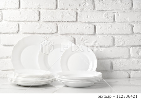 Set of dishes on table against brick wall background Set of dishes on table against brick wall background 112536421