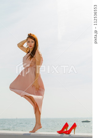 Woman dancing wearing long light pink dress 112536553
