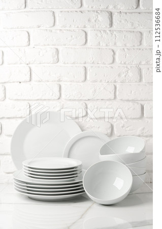Set of dishes on table against brick wall background Set of dishes on table against brick wall background 112536684