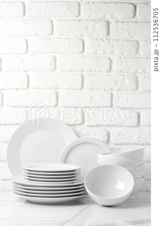 Set of dishes on table against brick wall background Set of dishes on table against brick wall background 112536705