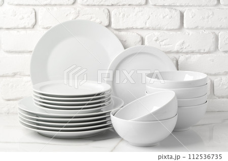 Set of dishes on table against brick wall background Set of dishes on table against brick wall background 112536735