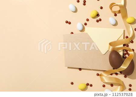Chocolate eggs with a paper envelope on a light background 112537028