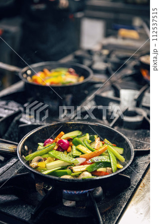 Sliced vegetables in the frying pan Sliced vegetables in the frying pan 112537515