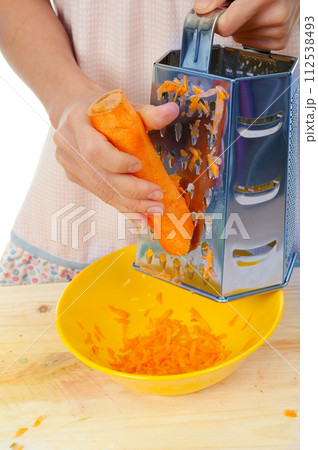Hand holding carrot vegetable grater Hand holding carrot vegetable grater 112538493