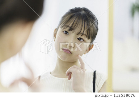 朝鏡を見て悩む小学生の女の子 112539076