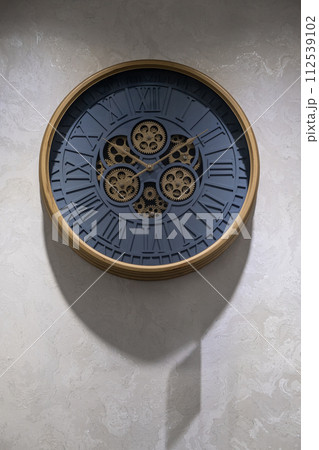 A round clock on the wall indicates the exact time. decor in the room A round clock on the wall indicates the exact time. decor in the room 112539102