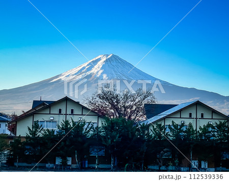 A mountain is in the background of a town with houses in the foreground A mountain is in the background of a town with houses in the foreground 112539336