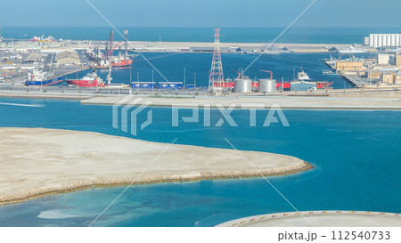 Big cargo ship at industrial port timelapse aerial view from above at evening in Abu Dhabi Big cargo ship at industrial port timelapse aerial view from above at evening in Abu Dhabi 112540733