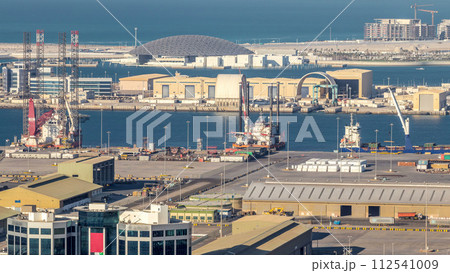 Big cargo ship at industrial port timelapse aerial fiew from above at evening in Abu Dhabi Big cargo ship at industrial port timelapse aerial fiew from above at evening in Abu Dhabi 112541009