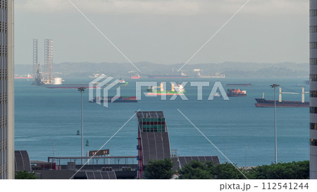 Various cargo ships waiting to load and unload in the harbour near the busiest port of Singapore aerial timelapse 112541244