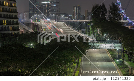 Traffic with cars on a street and urban scene in the central district of Singapore night timelapse 112541329