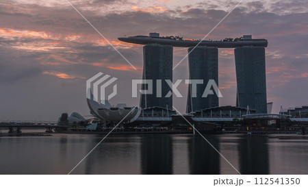 Sunrise near Marina Bay Sands Hotel dominates the skyline at Marina Bay in Singapore timelapse. 112541350