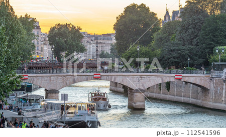 River and bridge near Notre Dame De Paris cathedral day to night timelapse after sunset. 112541596