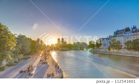 Rear view of Notre Dame De Paris cathedral at sunset with sun in the frame timelapse. 112541601