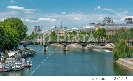 Touristic boat passes below Pont des Arts, on boat station on Seine river timelapse in Paris. 112542123