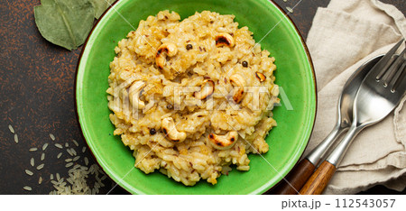 Ven Pongal (Khara Pongal), traditional Indian savoury rice dish made during celebrating Pongal festival, served in bowl top view on concrete rustic background 112543057